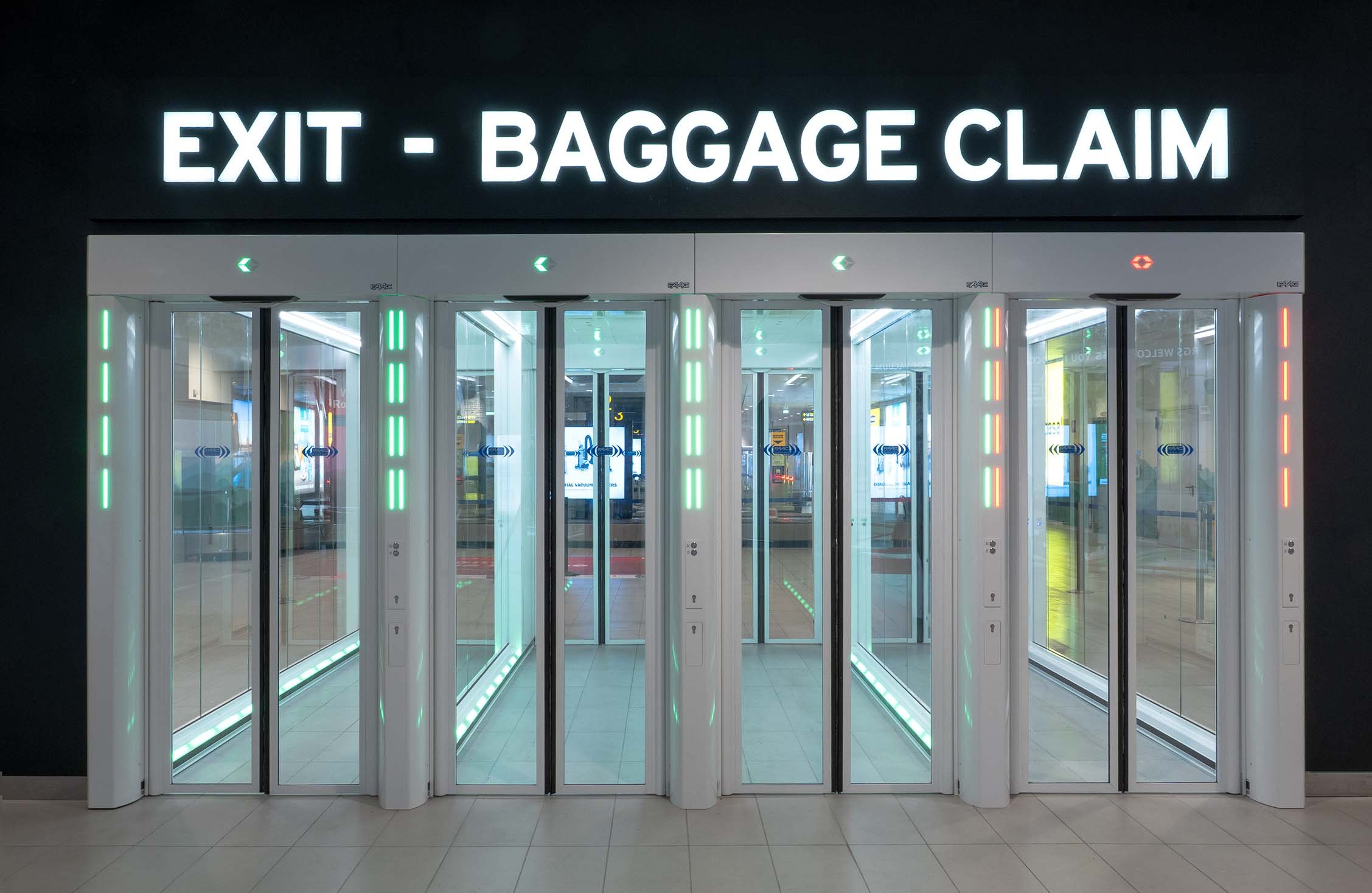 Quattro One-Way Corridors FAAC con segnaletica LED nella Sala Arrivi Schengen dell'Aeroporto di Bologna