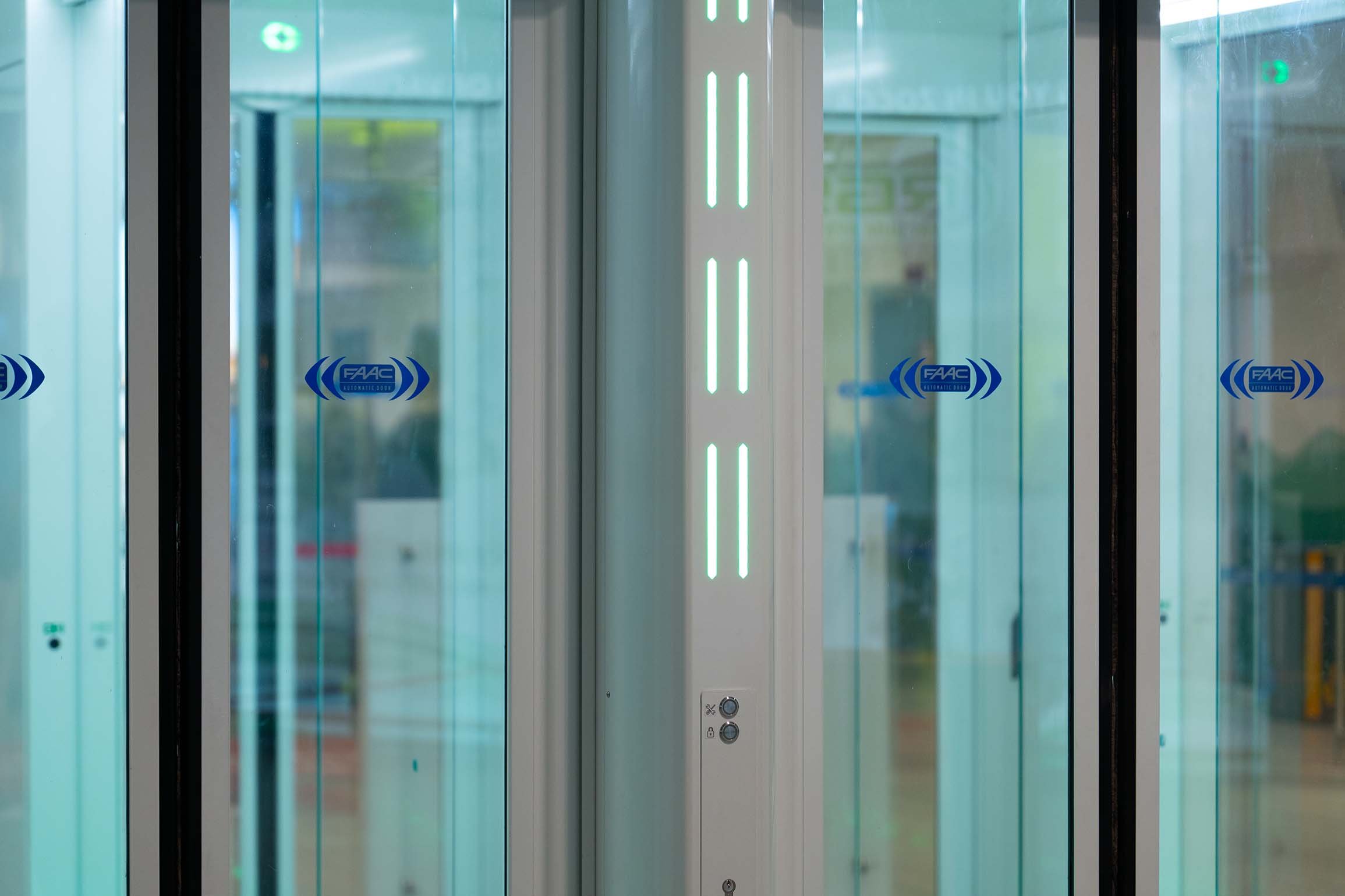 Dettaglio della segnaletica LED integrata e delle superfici vetrate di un One-Way Corridor FAAC installato presso l'Aeroporto di Bologna